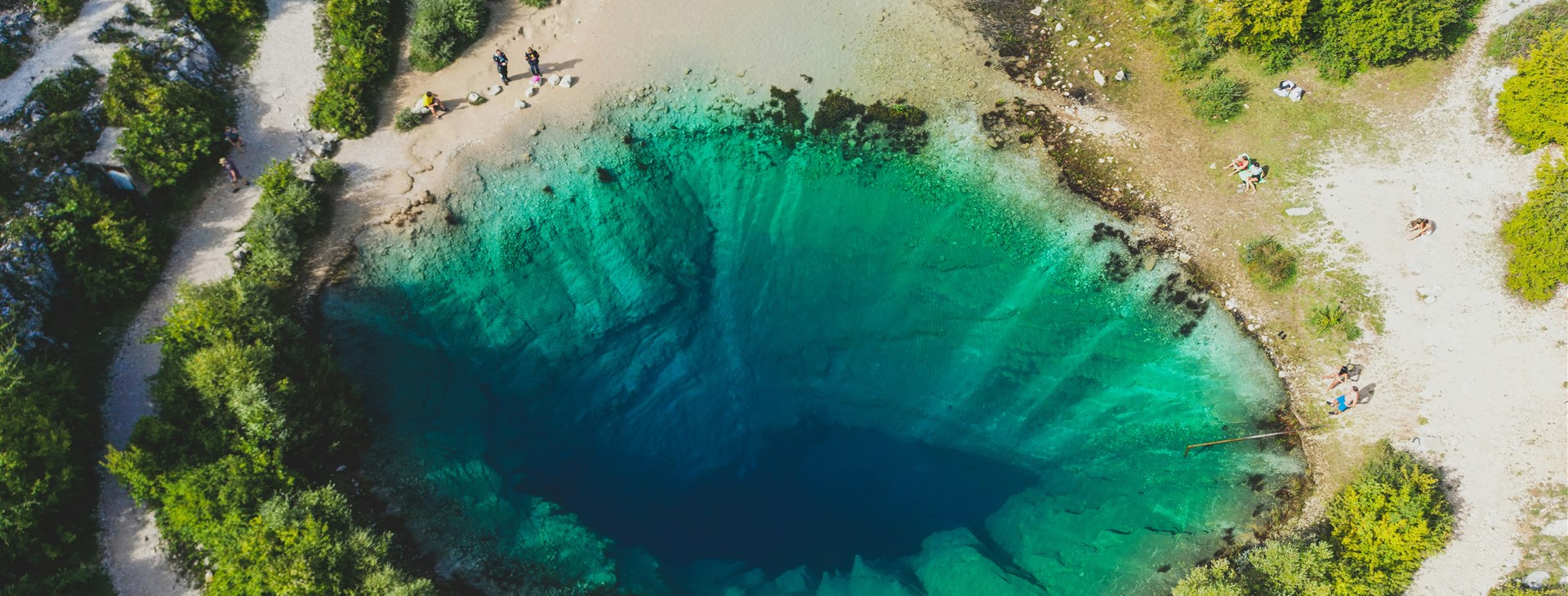 Pramen řeky Cetiny, který při pohledu z ptačí perspektivy vypadá jako velké zelenomodré oko vedoucí do hlubin země. Foto: Laurynas Žižys
